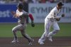 Boston Red Sox's Alex Bregman, left, heads to third base on his way to scoring from second base off an RBI single by Jarren Duran as San Diego Padres third baseman Manny Machado runs during the first inning of a baseball game Saturday, Aug. 9, 2025, in San Diego. (AP Photo/Gregory Bull)