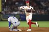 Los Angeles Angels shortstop Zach Neto (9) throws to first base to complete a double play as Los Angeles Dodgers designated hitter Shohei Ohtani (17) slides into second base during the sixth inning of a baseball game, Monday, Aug. 11, 2025, in Anaheim, Calif. (AP Photo/Jessie Alcheh)