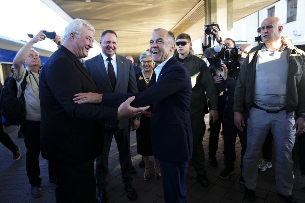 Prime Minister Mark Carney, middle, is greeted by Ukrainian Minister for Foreign Affairs Andrii Sybiha as he
arrives in Kyiv Ukraine, on Sunday, Aug. 24, 2025. THE CANADIAN PRESS/Sean Kilpatrick