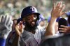 Texas Rangers' Adolis García celebrates in the dugout after scoring during the ninth inning of a baseball game against the Athletics Saturday, Aug. 30, 2025, in West Sacramento, Calif. (AP Photo/Sara Nevis)