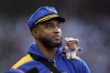 FILE - Seattle Mariners' Víctor Robles looks to the field from the dugout with a miniature team mascot on his shoulder against the Miami Marlins of a baseball game, April 25, 2025, in Seattle. (AP Photo/John Froschauer, File)