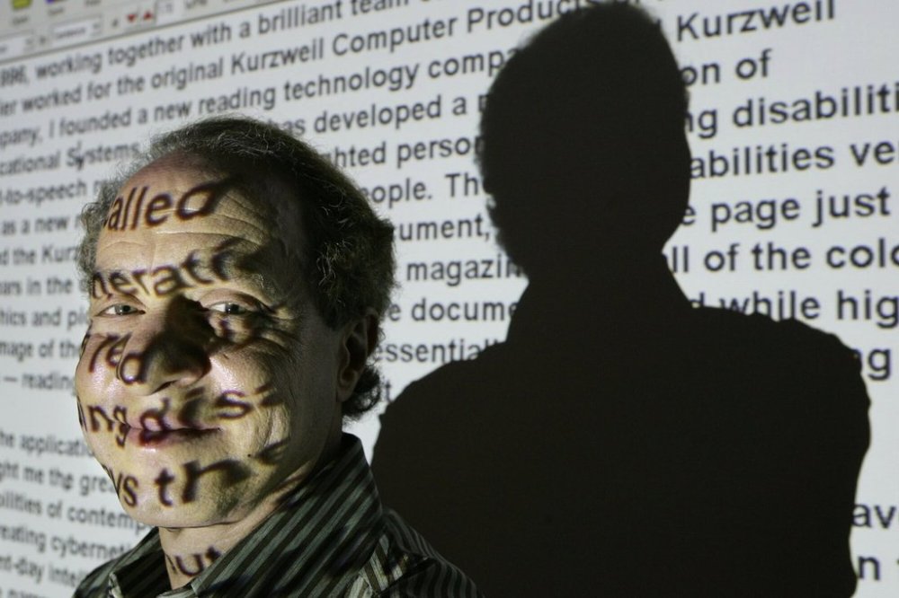 FILE - Author and inventor Ray Kurzweil, 56, stands for a portrait in front of words from his internet site projected on a screen in his office in Wellesley, Mass., Jan. 12, 2005. (AP Photo/Steven Senne, File)