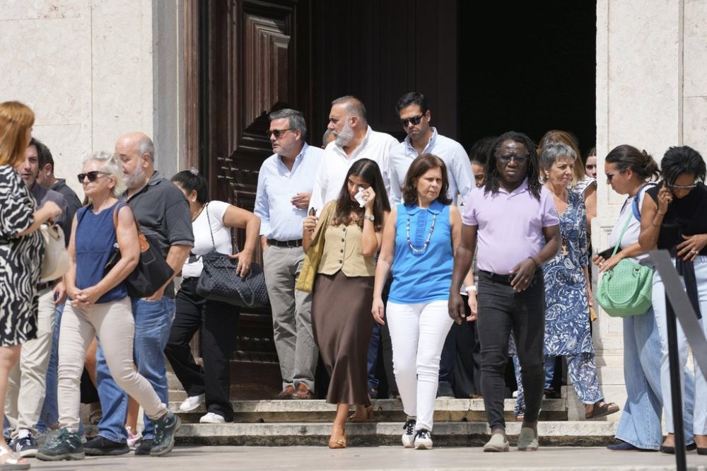 Relatives, friends and colleagues leave a church service for the four coworkers of the charitable organization Santa Casa da Misericordia who perished in the derailment and crash of the Gloria funicular, at the Church of Saint Roch in Lisbon, Friday, Sept. 5, 2025. (AP Photo/Armando Franca)