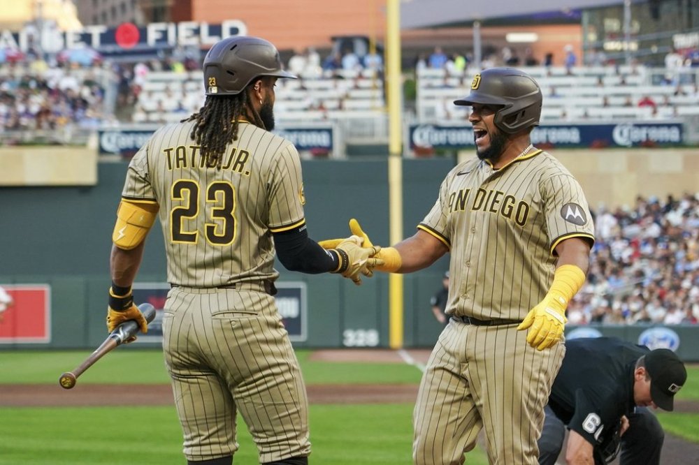 San Diego Padres' Elias Díaz, right, celebrates with Fernando Tatis Jr. after hitting a home run against Minnesota Twins pitcher Taj Bradley (26) during the fifth inning of a baseball game Saturday, Aug. 30, 2025, in Minneapolis. (AP Photo/Craig Lassig)