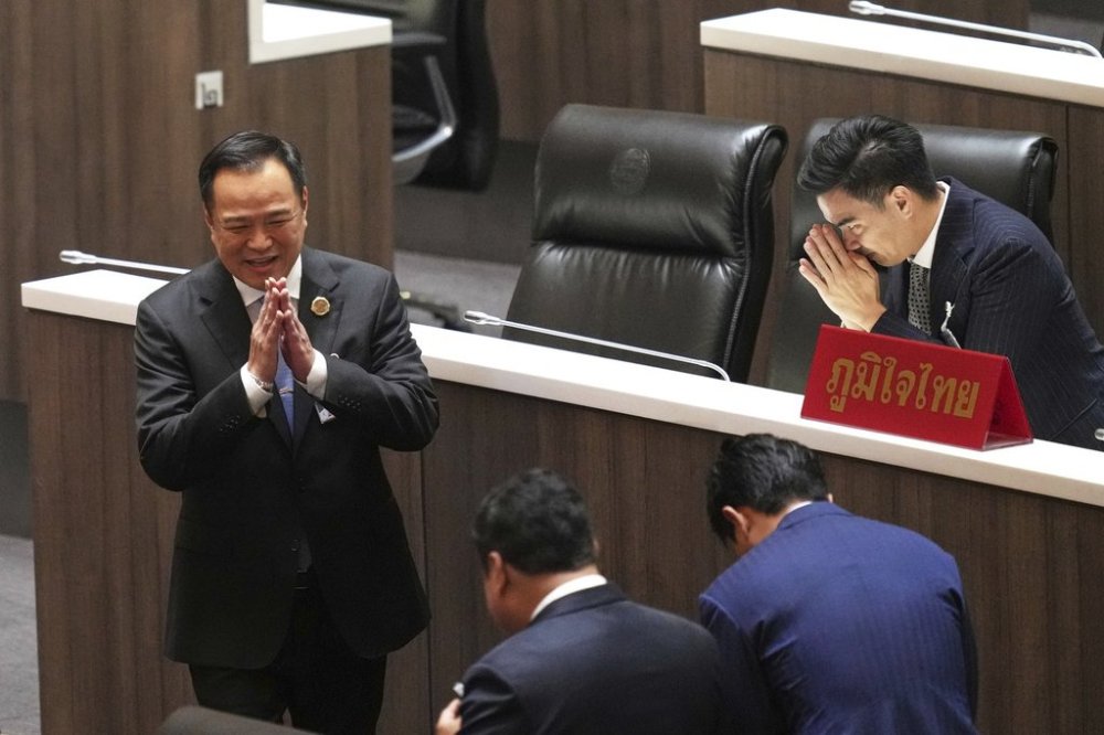 Leader of Bhumjai Thai Party Anutin Charnvirakul, left, talks to lawmakers at Parliament in Bangkok, Thailand, Friday, Sept. 5, 2025. (AP Photo/Sakchai Lalit)
