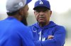Los Angeles Dodgers manager Dave Roberts, back, talks with right fielder Teoscar Hernández as he warms up before a baseball game against the Colorado Rockies Wednesday, Aug. 20, 2025, in Denver. (AP Photo/David Zalubowski)