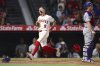 Los Angeles Angels' Zach Neto (9) runs to score off an RBI single by designated hitter Mike Trout as Los Angeles Dodgers catcher Will Smith, right, looks on during the fifth inning of a baseball game, Monday, Aug. 11, 2025, in Anaheim, Calif. (AP Photo/Jessie Alcheh)