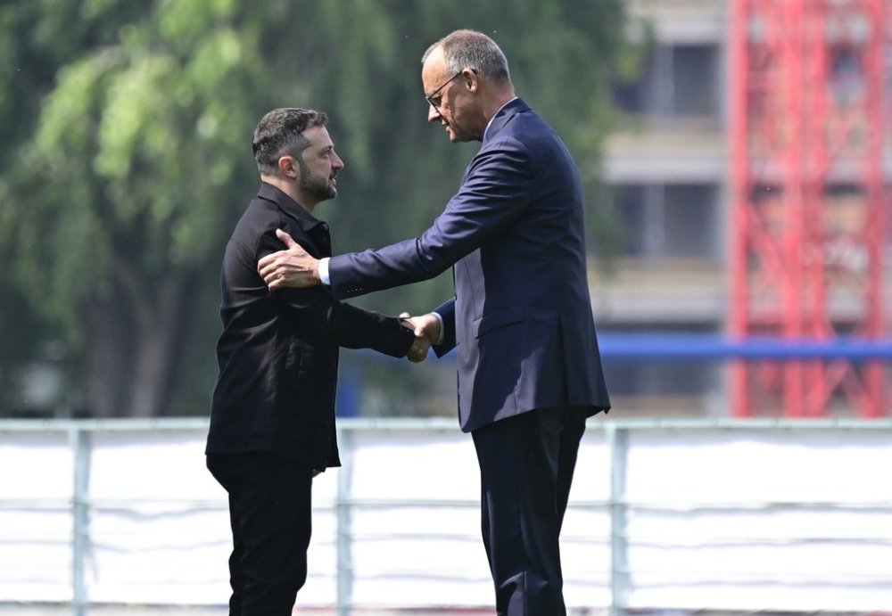 Ukrainian President Volodymyr Zelenskyy, left, is welcomed by German Chancellor Friedrich Merz upon arrival in the garden of the chancellery in Berlin, Germany, Wednesday, Aug. 13, 2025 to join a video conference of European leaders with the US President on the Ukraine war. (John MacDougall/Pool Photo via AP)