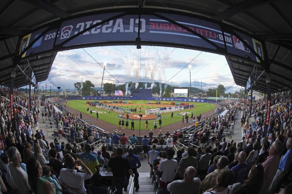 The 20 Little League teams participating in the Little League World Series line the infield as the Seattle Mariners, line the third baseline, and the New York Mets line the first baseline before the Little League Classic baseball game at Bowman Field in Williamsport, Pa., Sunday, Aug. 17, 2025. (AP Photo/Gene J. Puskar)