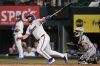Texas Rangers first baseman Jake Burger follows through on a run-scoring single as Arizona Diamondbacks catcher Adrian Del Castillo looks on in the 10th inning of a baseball game Monday, Aug. 11, 2025, in Arlington, Texas. (AP Photo/Tony Gutierrez)