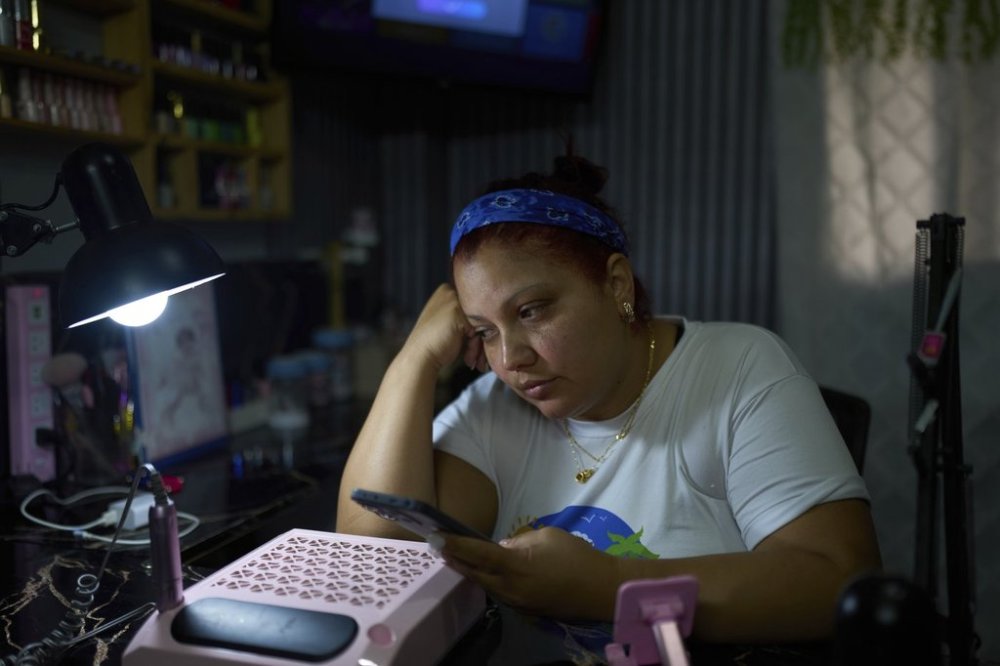 Syntia Caceres talks on the phone to her son, who was detained in the U.S. in July and her four-year-old granddaughter Aurore was placed in foster care in Georgia state, at her home in Caracas, Venezuela, Thursday, Sept. 4, 2025. (AP Photo/Ariana Cubillos)
