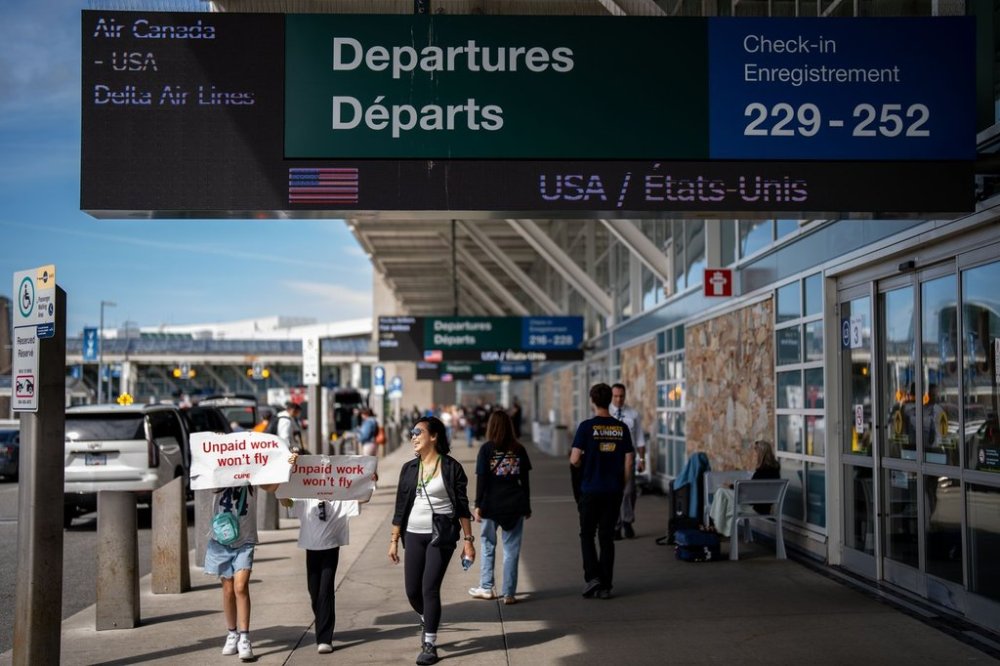 Strike supporters march around the departures level at the Vancouver International Airport in Richmond, B.C., on Sunday, Aug. 17, 2025. Air Canada made the call to halt a return to operation as flight attendants continue to strike. THE CANADIAN PRESS/Ethan Cairns