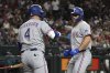 Texas Rangers' Wyatt Langford, right, celebrates with Joc Pederson (4) after hitting a solo home run against the Arizona Diamondbacks in the sixth inning of a baseball game, Monday, Sept. 1, 2025, in Phoenix. (AP Photo/Rick Scuteri)