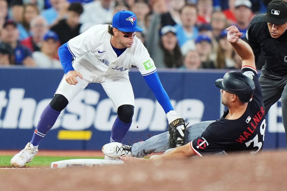 Blue Jays third baseman Ernie Clement (top) tags out Minnesota Twins outfielder Matt Wallner (38) at third base during the eighth inning of a Major League Baseball game in Toronto on Tuesday, Aug. 26, 2025. THE CANADIAN PRESS/Frank Gunn