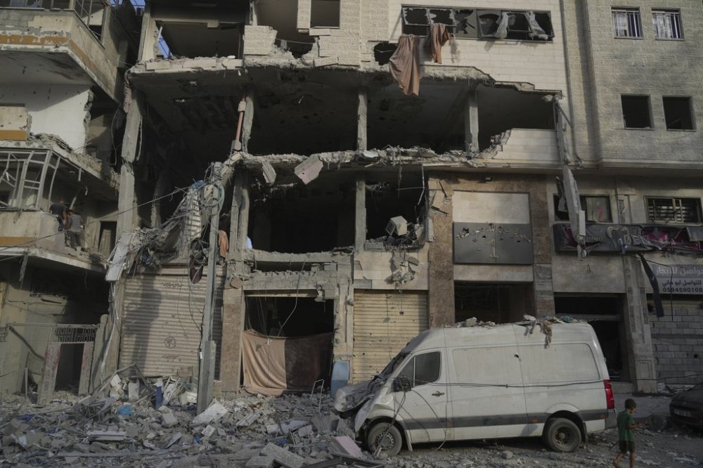 A Palestinian boy walks past a heavily damaged building in the Rimal neighborhood, in Gaza City, Sunday, Aug. 31, 2025, a day after it was hit by an Israeli military strike that killed several people. (AP Photo/Jehad Alshrafi)