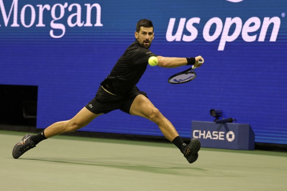 Novak Djokovic, of Serbia, returns a shot against Taylor Fritz, of the United States, during the quarterfinal round of the U.S. Open tennis championships, Tuesday, Sept. 2, 2025, in New York. (AP Photo/Adam Hunger)