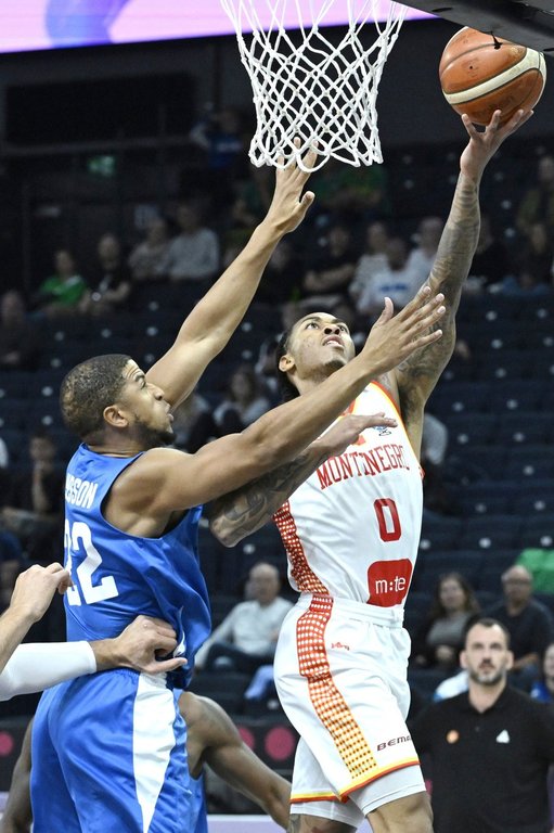 Britain's Myles Hesson, left, and Montenegro's Nikola Vucevic, right, challenge for the ball during the Eurobasket, European Basketball Championship, group B match between Montenegro and Great Britain in Tampere, Finland, Wednesday, Sept. 3, 2025. (Heikki Saukkomaa/Lehtikuva via AP)
