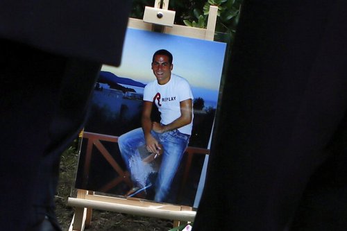 FILE - A picture of Ilan Halimi is seen at a makeshift memorial, in Sainte Genevieve des Bois, south suburb of Paris, Wednesday, Feb. 13, 2019 during a tribute ceremony (AP Photo/Francois Mori, File)