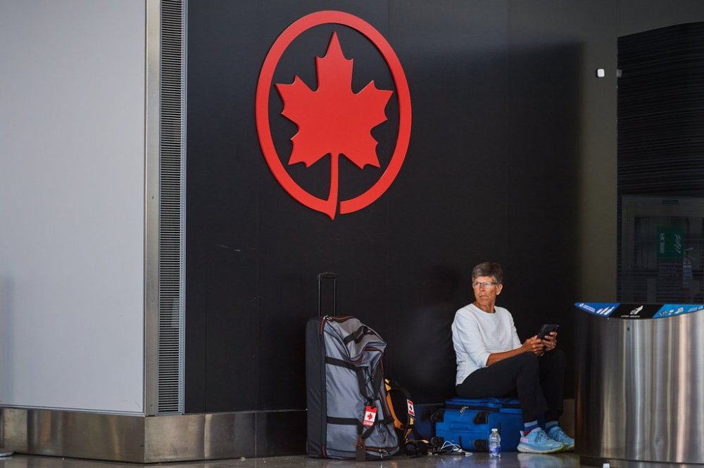 A traveller waits by the Air Canada departure gates as flight attendants picket at Pearson International Airport in Toronto, on Monday, Aug. 18, 2025. THE CANADIAN PRESS/Sammy Kogan