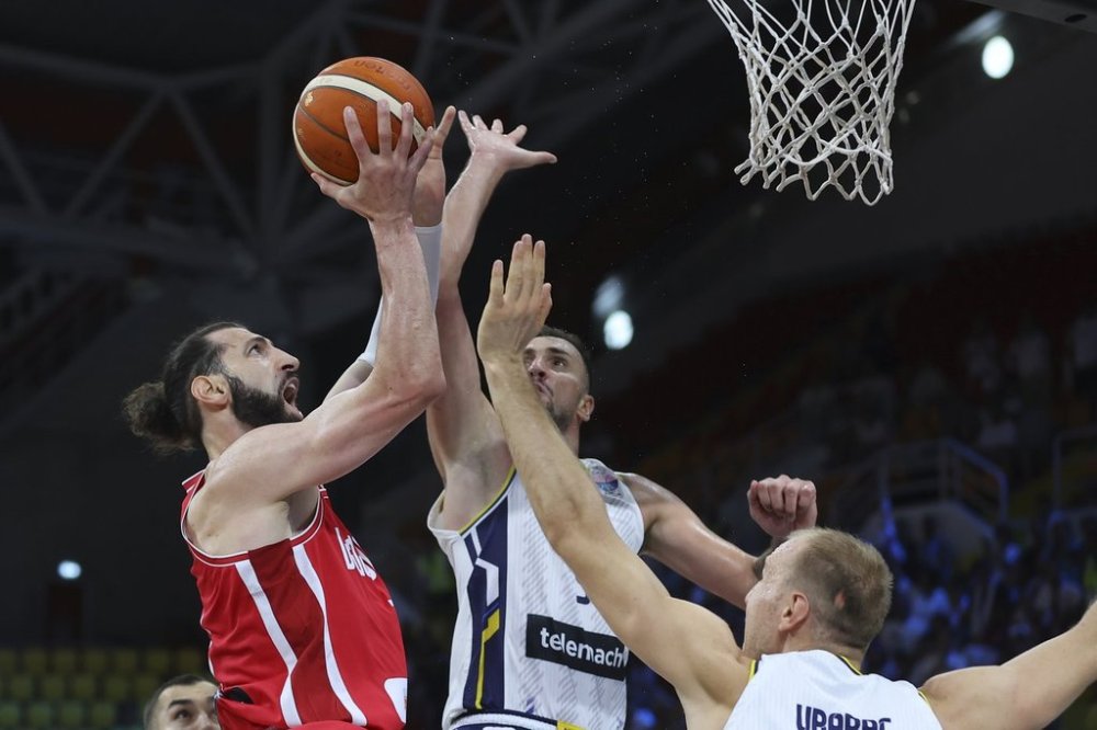 Georgia's Tornike Shengelia, left, goes to score as Bosnia's Adin Vrabac, bottom right, and Edin Atic defend during the Eurobasket, European Basketball Championship Group C match between Bosnia and Georgia at Spyros Kyprianou Arena, in Limassol, Cyprus, Thursday, Sept. 4, 2025. (AP Photo/Sakis Savvides)