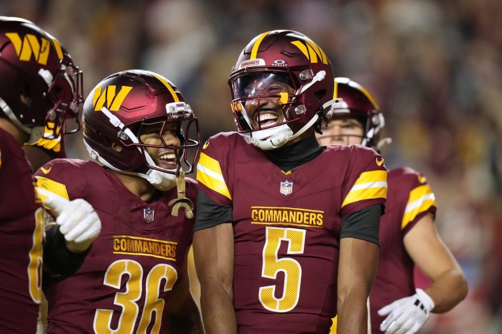 Washington Commanders quarterback Jayden Daniels (5) is congratulated by teammate Chris Rodriguez Jr. (36) after scoring during the first half of a preseason NFL football game Monday, Aug. 18, 2025, in Landover, Md. (AP Photo/Stephanie Scarbrough)