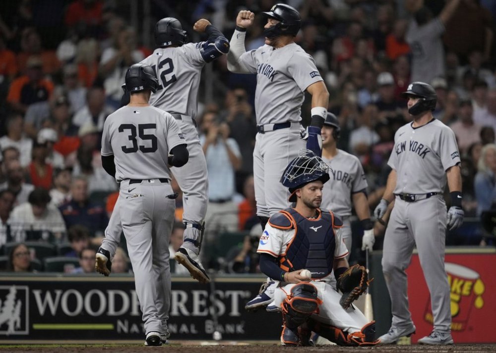 New York Yankees' Trent Grisham (12) celebrates with designated hitter Aaron Judge, top center, after hitting a grand slam during the fifth inning of a baseball game against the Houston Astros in Houston, Tuesday, Sept. 2, 2025. Paul Goldschmidt, Cody Bellinger, and Aaron Judge also scored. (AP Photo/Ashley Landis)