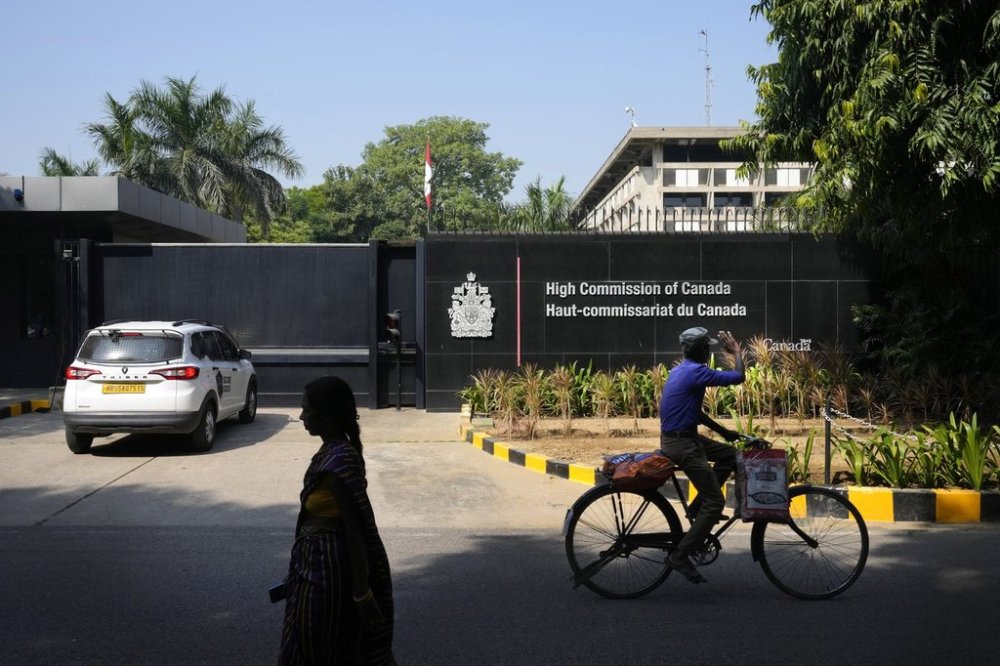 A cyclist pedals past the Canadian High Commission in New Delhi, India, Tuesday, Oct. 15, 2024. (AP Photo/Manish Swarup)