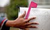 In this Feb. 7, 2013 file photo, U.S. Postal Service letter carrier Jamesa Euler, turns down the flag on a mailbox while delivering mail in the Cabbagetown of Atlanta. (AP Photo/David Goldman, File)