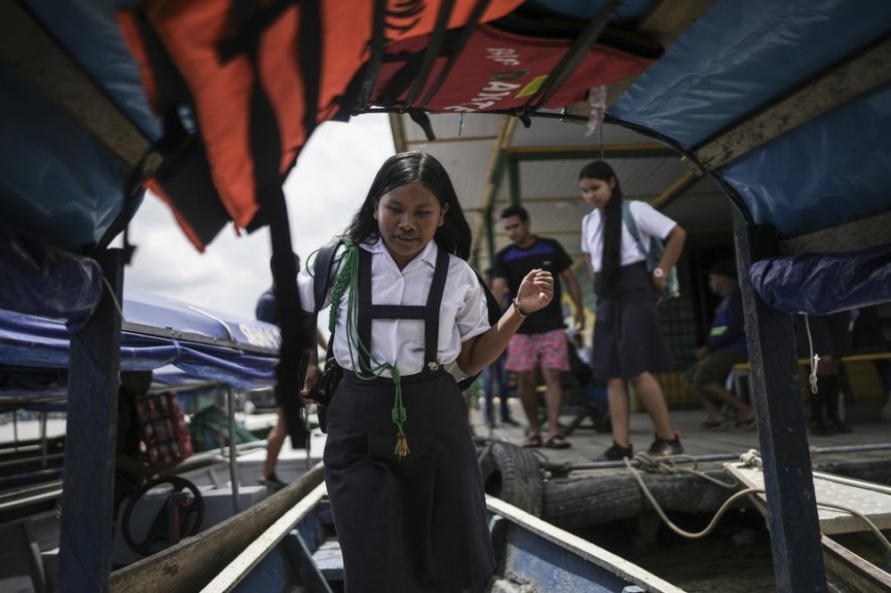 Students board Salvador Mitidieri's boat in Tabatinga, Brazil, to commute to school in Santa Rosa, Peru, Monday, Aug. 18, 2025. (AP Photo/Ivan Valencia)