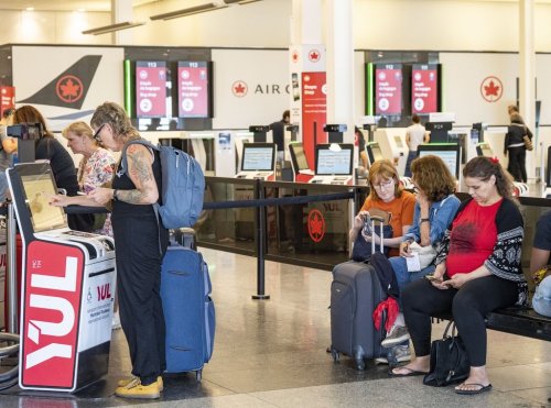An Air Canada traveller gets her boarding pass at Montreal-Pierre Elliott Trudeau International Airport in Dorval, Que., on Tuesday,  Aug. 19, 2025. THE CANADIAN PRESS/Christinne Muschi