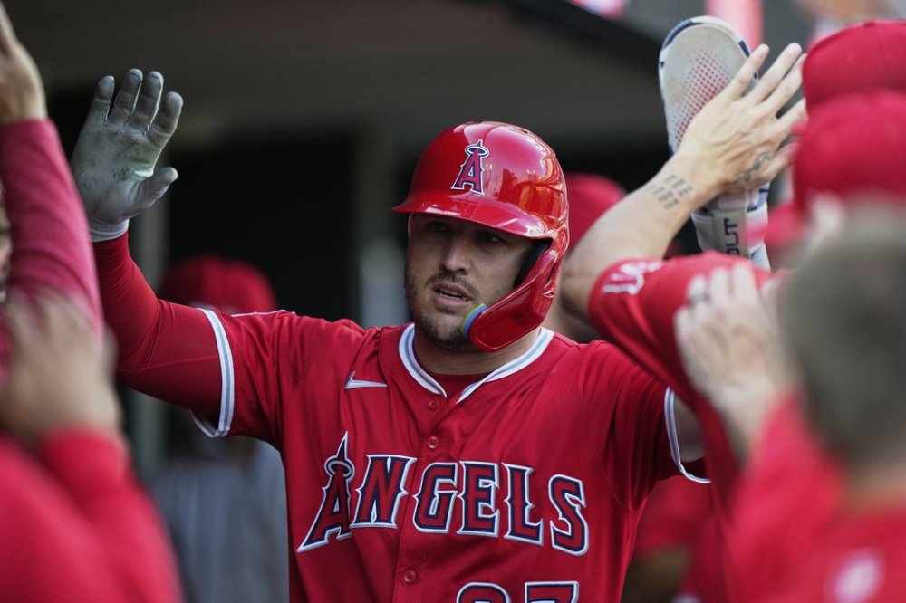 Los Angeles Angels designated hitter Mike Trout celebrates in the dugout after scoring off a double hit by Taylor Ward during the first inning of a baseball game against the Detroit Tigers, Saturday, Aug. 9, 2025, in Detroit. (AP Photo/Ryan Sun)