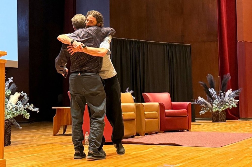 Skier and filmmaker Alex Hackel hugs his father at The Neurodiversity Alliance's leadership summit in Denver, August 9, 2025. (AP Photo/James Pollard)