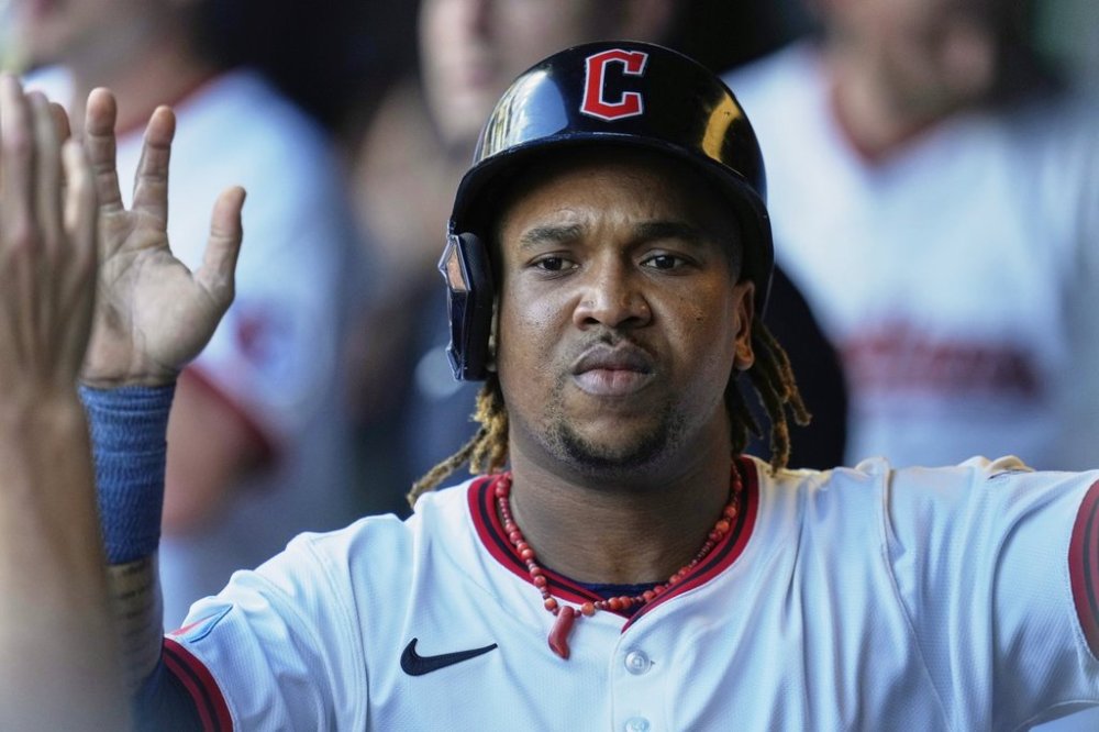 Cleveland Guardians' Jose Ramirez is congratulated in the dugout after scoring in the first inning of a baseball game against the Miami Marlins in Cleveland, Thursday, Aug. 14, 2025. (AP Photo/Sue Ogrocki)