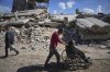 FILE - Wasem Attiya pushes his father, Mohamed, 54, in a wheelchair as they head to Shifa hospital in Gaza City for a dialysis session, Monday, April 14, 2025. (AP Photo/Jehad Alshrafi, File)