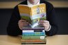 Amanda Darrow, director of youth, family and education programs at the Utah Pride Center, poses with books that have been the subject of complaints from parents in Salt Lake City on Dec. 16, 2021. (AP Photo/Rick Bowmer)