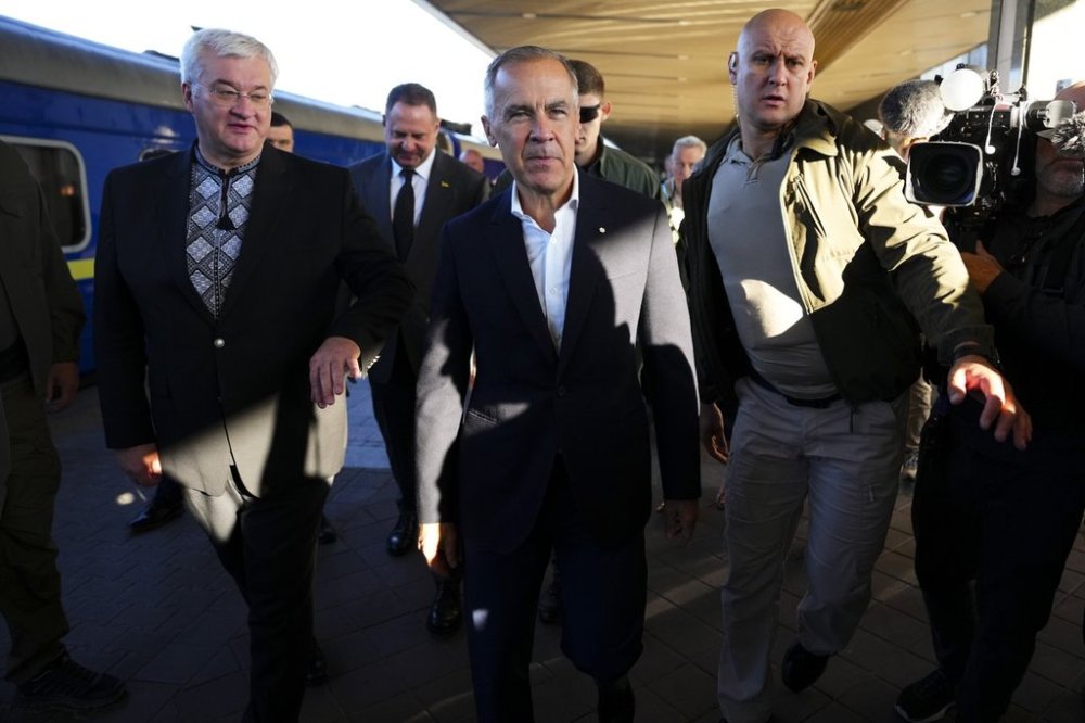 Prime Minister Mark Carney, middle, walks with Ukrainian Minister for Foreign Affairs Andrii Sybiha, left, as he arrives in Kyiv, Ukraine, on Sunday, Aug. 24, 2025. THE CANADIAN PRESS/Sean Kilpatrick