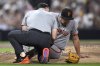 San Francisco Giants starting pitcher Landen Roupp, right, is checked by a trainer after being hit by a line drive during the third inning of a baseball game against the San Diego Padres Wednesday, Aug. 20, 2025, in San Diego. (AP Photo/Orlando Ramirez)