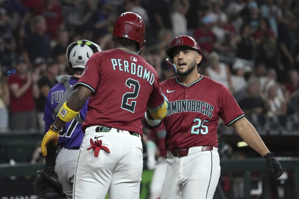 Arizona Diamondbacks' Adrian Del Castillo celebrates with Geraldo Perdomo (2) after hitting a three-run home run against the Colorado Rockies in the first inning of a baseball game, Sunday, Aug 10, 2025, in Phoenix. (AP Photo/Rick Scuteri)