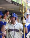 Seattle Mariners' Cal Raleigh celebrates in the dugout with the trident after hitting a two-run home run against the Athletics during the second inning of a baseball game, breaking the record for single-season home runs by a catcher at 49, Sunday, Aug. 24, 2025, in Seattle. (AP Photo/Lindsey Wasson)