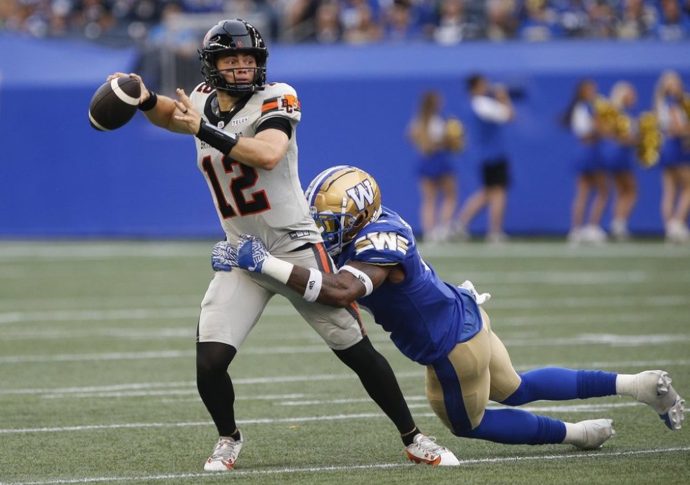 BC Lions quarterback Nathan Rourke (12) gets wrapped up by Winnipeg Blue Bombers' Willie Jefferson (5) during first half CFL action in Winnipeg Thursday, June 12, 2025. THE CANADIAN PRESS/John Woods