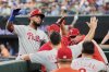 Philadelphia Phillies' Edmundo Sosa, left, celebrates his solo home run with the team in the fifth inning of a baseball game against the Texas Rangers, Sunday, Aug. 10, 2025, in Arlington, Texas. (AP Photo/Tony Gutierrez)