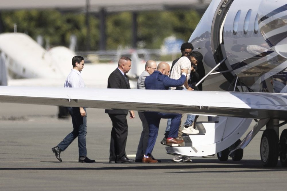 Harjinder Singh is escorted onto an airplane by Florida Lt. Gov. Jay Collins and law enforcement on Thursday, Aug. 21, 2025, in Stockton, Calif. (AP Photo/Benjamin Fanjoy)