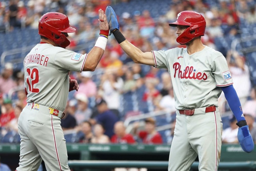 Philadelphia Phillies' Kyle Schwarber celebrates with Philadelphia Phillies' Trea Turner after scoring a run during the first inning of a baseball game against the Washington Nationals, Friday, Aug. 15, 2025, in Washington. (AP Photo/Daniel Kucin Jr.)