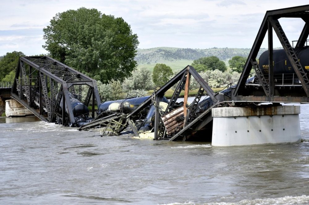 FILE - Several train cars are immersed in the Yellowstone River after a bridge collapse near Columbus, Mont., June 24, 2023. (AP Photo/Matthew Brown, File)