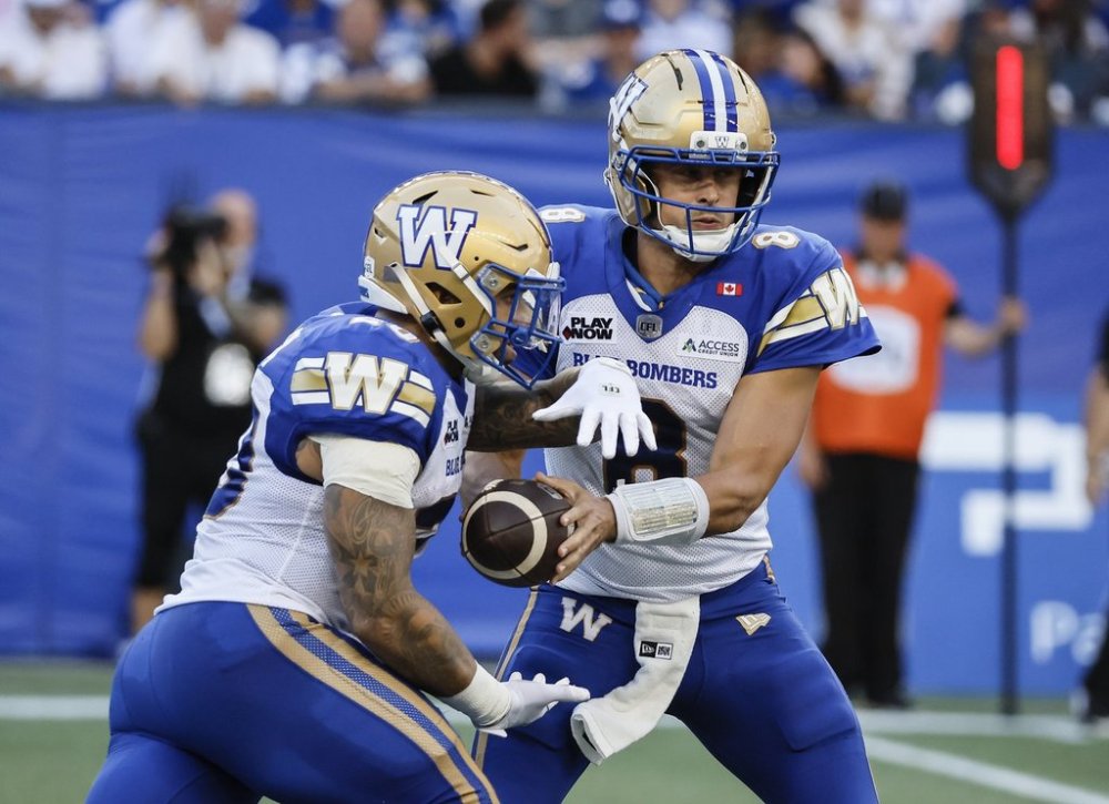 Winnipeg Blue Bombers quarterback Zach Collaros (8) hands off to Brady Oliveira (20) against the Ottawa Redblacks during first half CFL action in Winnipeg Thursday, August 14, 2025. THE CANADIAN PRESS/John Woods