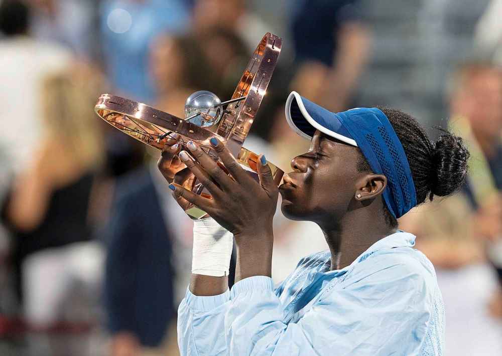 Victoria Mboko of Canada kisses the trophy following her win over Naomi Osaka of Japan during finals tennis action at the National Bank Open in Montreal, Thursday, Aug. 7, 2025. THE CANADIAN PRESS/Christinne Muschi
