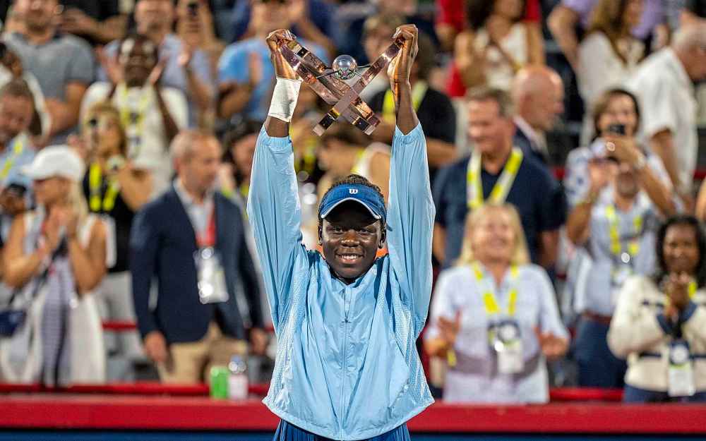 Victoria Mboko of Canada hoists the trophy following her win over Naomi Osaka of Japan during finals tennis action at the National Bank Open in Montreal, Thursday, Aug. 7, 2025. THE CANADIAN PRESS/Christinne Muschi