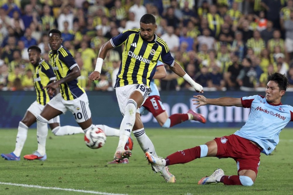 Fenerbahce's Youssef En-Nesyri, center, attempts a shot at goal against Feyenoord's Tsuyoshi Watanabe during a Champions League third qualifying round second leg soccer match between Fenerbahce and Feyenoord at the Ulker stadium, in Istanbul, Turkey, Tuesday, Aug. 12, 2025. (Huseyin Yavuz/Dia Photo via AP)