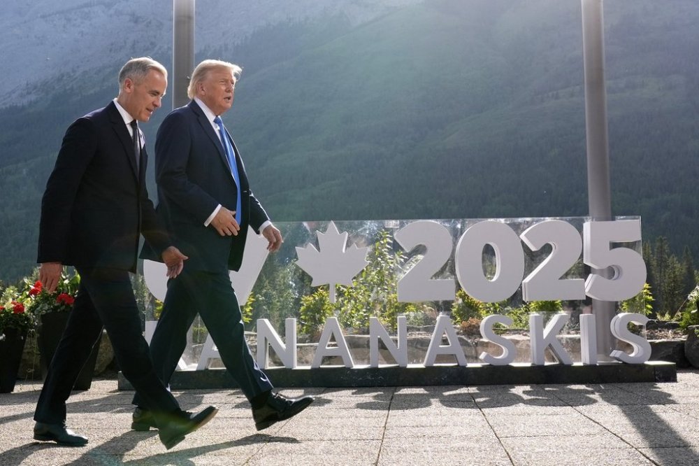 Canada's Prime Minister Mark Carney walks with President Donald Trump after a group photo at the G7 Summit, Monday, June 16, 2025, in Kananaskis, Canada. THE CANADIAN PRESS/AP-Mark Schiefelbein
