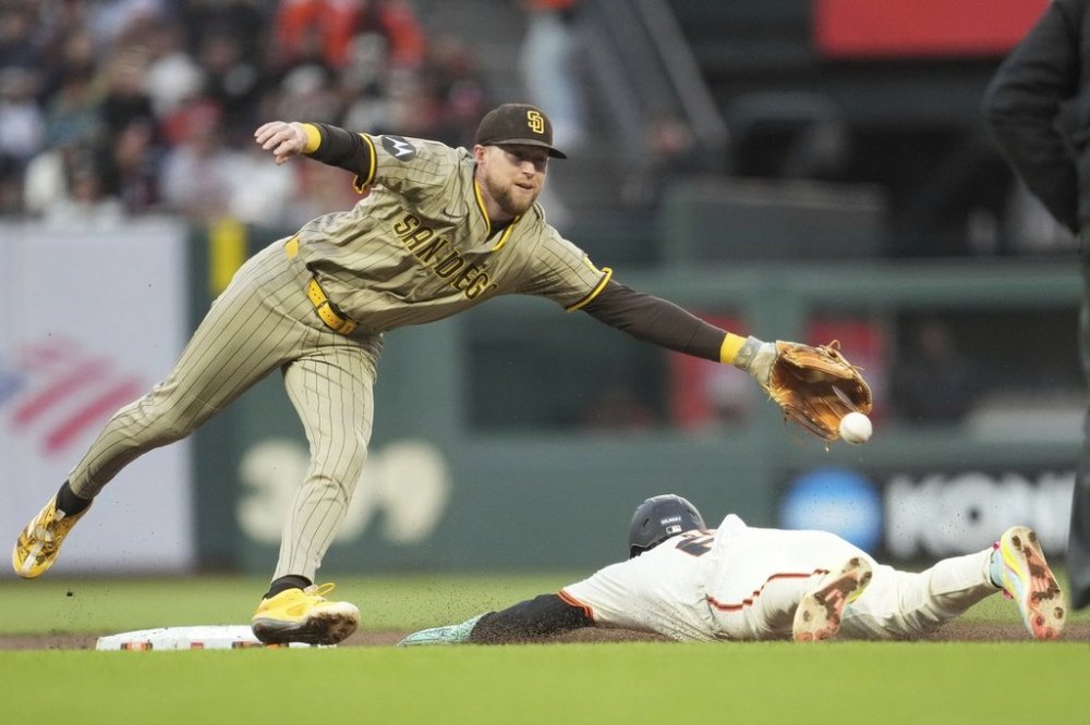 San Francisco Giants' Drew Gilbert, bottom, steals second base under San Diego Padres second baseman Jake Cronenworth during the third inning of a baseball game in San Francisco, Monday, Aug. 11, 2025. (AP Photo/Jeff Chiu)